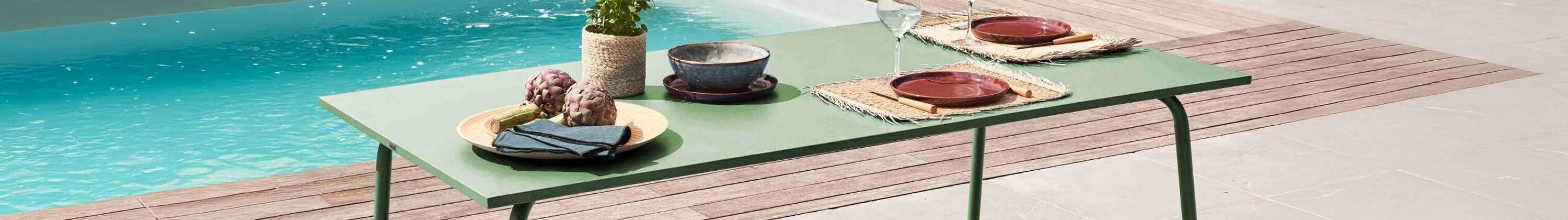 mesa de jardín de metal junto a piscina