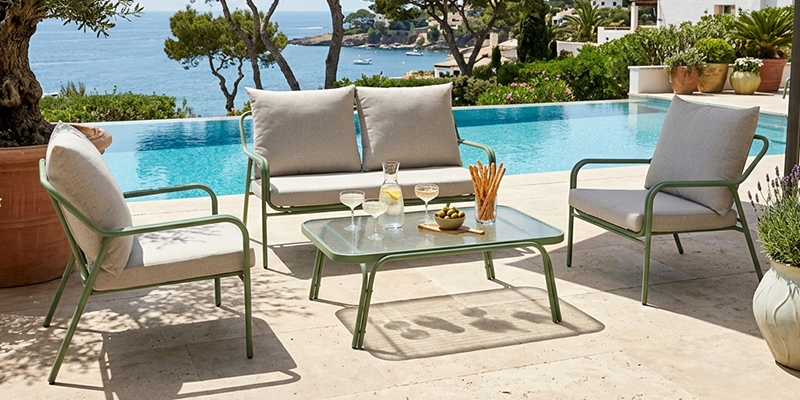 Conjunto bajo de jardín de aluminio para 4 personas con mesa de centro junto a una piscina